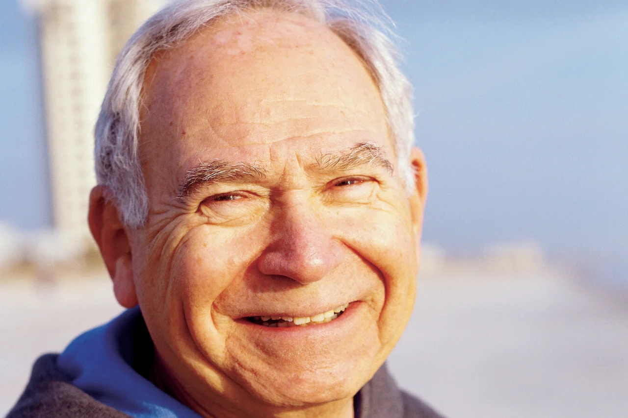 A portrait of an eldery man smiling on a beach